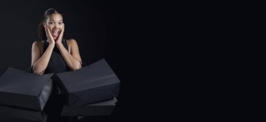 Bir sürü alışveriş çantası tutan ve gülümseyen mutlu zarif kadın, Kara Cuma indirim konsepti.