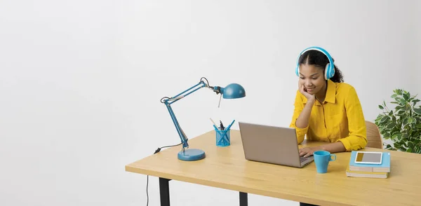 Junge Frau Sitzt Schreibtisch Und Schaut Sich Videos Online Auf lizenzfreie Stockbilder
