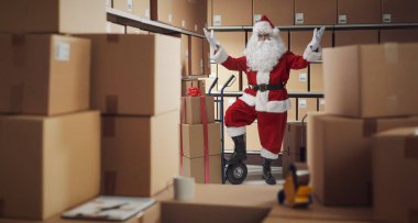 Depoda çalışan neşeli Noel Baba, Noel hediyelerini teslim ediyor.
