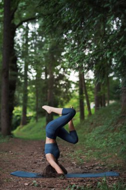 Güzel, formda bir kadın yoga yapıyor, sağlıklı bir yaşam tarzı ve refah kavramı.