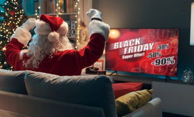 Noel Baba evdeki kanepede oturup televizyon seyrediyor. Kara Cuma reklamını seyrediyor ve el kaldırarak kutluyor.
