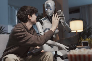 Mutlu çocuk ve yapay zeka beşlik çakıyor, evde video oyunları oynuyorlar, insan-robot etkileşimi konsepti.