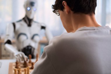 Erkek ve robot arasında geleceksel bir satranç maçı yapılıyor..