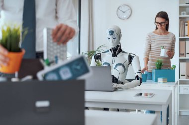 İşten çıkarılan işadamları eşyalarını toplayıp ofisten ayrılırken, bir robot masada oturuyor ve çalışıyor: Yapay zekanın iş üzerindeki etkisi
