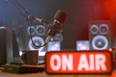 Radyo yayın istasyonu profesyonel ekipmanları ve ön planda On Air Light tabelası