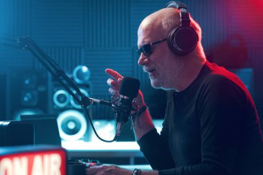 Kulaklık takan ve mikrofona konuşan profesyonel radyo sunucusu: radyo ve iletişim konsepti