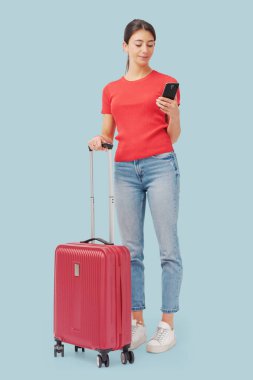 Tramvay çantasıyla seyahat eden ve akıllı telefonunu kullanan bir turist.