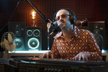 Stüdyo, sanat ve eğlence konseptinde şarkı söyleyip çalan şık bir müzisyen.