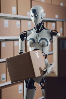 Bir dağıtım deposunda çalışan ve teslimat kutuları, otomasyon ve lojistik konsepti taşıyan etkili yapay zeka robotu.