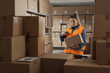 Depo stokçusu teslimat kutusu, lojistik ve nakliye konseptinde barkod taraması yapıyor.