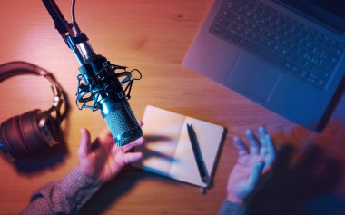 Ev stüdyodaki Livestreamer gece çevrimiçi yayın içeriği: ses donanımı, dizüstü bilgisayar ve mikrofon olan masa, üst görünüm