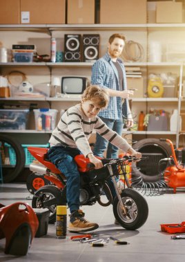 Bakıcı baba garajda oğlunun motosikletini kontrol ediyor. Aile ve birliktelik kavramı.
