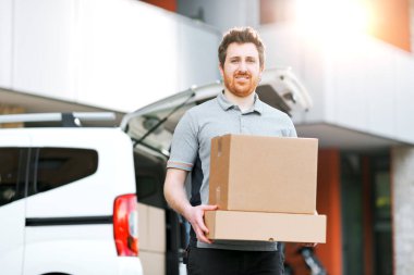 Paket taşıyan gülümseyen bir teslimatçının portresi: