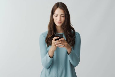 Akıllı telefon, sosyal medya ve iletişim konseptiyle sohbet eden güzel bir genç kadının portresi