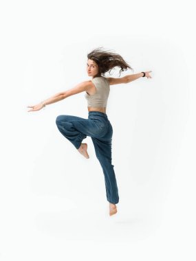 Genç ve zinde bir kadının portresi atlama ve hareket, enerji ve canlılık kavramı, beyaz arka planda izole.