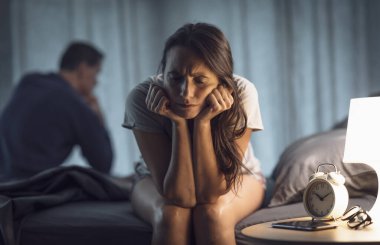 Yatak odasında tartışan bir çift stresli ve birbirleriyle konuşmuyorlar.