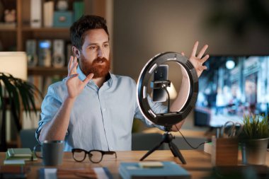 Profesyonel youtuber ve evde çalışan etkili kişi, akıllı telefon ve halka ışığı kullanarak yeni bir video kaydediyor.