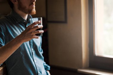 Bir bardak kola içme ve uzak bir pencere yanında seyir yenilikçi genç adam