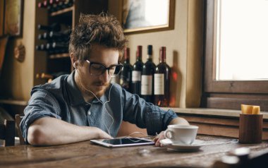 İnek hipster gözlüklü, masanın ve tablet kullanma