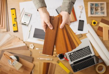 Profesyonel iç tasarımcı holding ahşap renk örnekleri Süpürgelik ve Süpürgelik, eller arka plan üstünde okul sırası ile yakın çekim