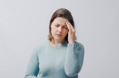 Stresli kadın kafasına dokunuyor, şiddetli baş ağrısı çekiyor, beyaz arka planda izole edilmiş.