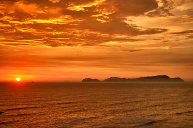San Lorenzo Adası 'nda güneş batarken, Miraflores' in manzarası saf büyüye dönüşür. Okyanus sonsuz ufukların fısıldarken adanın silueti gökyüzüne karşı alevler saçar.. 