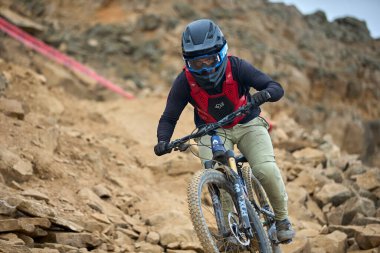 Yokuş aşağı bir MTB binicisi, arka planda Pasifik Okyanusu ve Lima şehrinin görkemli manzarasıyla El Morro Solar 'ın engebeli hatlarını oyuyor..