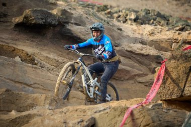 Yokuş aşağı bir MTB binicisi, arka planda Pasifik Okyanusu ve Lima şehrinin görkemli manzarasıyla El Morro Solar 'ın engebeli hatlarını oyuyor..