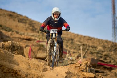 Yokuş aşağı bir MTB binicisi, arka planda Pasifik Okyanusu ve Lima şehrinin görkemli manzarasıyla El Morro Solar 'ın engebeli hatlarını oyuyor..