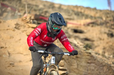 Yokuş aşağı bir MTB binicisi, arka planda Pasifik Okyanusu ve Lima şehrinin görkemli manzarasıyla El Morro Solar 'ın engebeli hatlarını oyuyor..