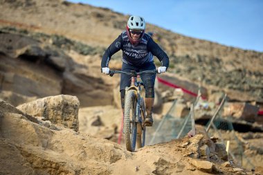 Yokuş aşağı bir MTB binicisi, arka planda Pasifik Okyanusu ve Lima şehrinin görkemli manzarasıyla El Morro Solar 'ın engebeli hatlarını oyuyor..