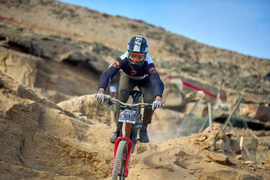 Yokuş aşağı bir MTB binicisi, arka planda Pasifik Okyanusu ve Lima şehrinin görkemli manzarasıyla El Morro Solar 'ın engebeli hatlarını oyuyor..