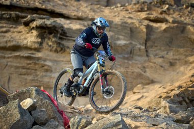 Yokuş aşağı bir MTB binicisi, arka planda Pasifik Okyanusu ve Lima şehrinin görkemli manzarasıyla El Morro Solar 'ın engebeli hatlarını oyuyor..