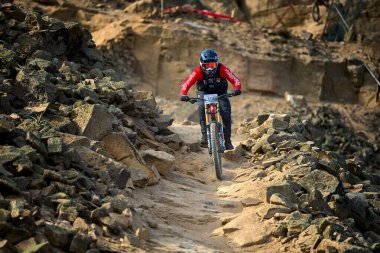 Yokuş aşağı bir MTB binicisi, arka planda Pasifik Okyanusu ve Lima şehrinin görkemli manzarasıyla El Morro Solar 'ın engebeli hatlarını oyuyor..