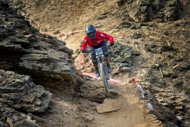 Yokuş aşağı bir MTB binicisi, arka planda Pasifik Okyanusu ve Lima şehrinin görkemli manzarasıyla El Morro Solar 'ın engebeli hatlarını oyuyor..