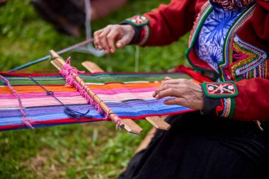 Bir dokumacının elleri, nesiller boyu yetenek, sabır ve yaratıcılık barındırır. Basit iplikleri sanat eserlerine dönüştürür. Her dokuma bir yolculuktur, her düğüm bir anıdır. Chinchero Cusco Peru.