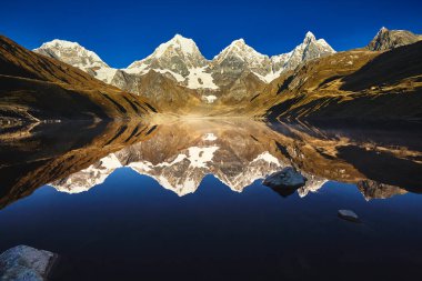 Cordillera Huayhuash 'ın kalbine yerleşmiş bu nefes kesici göl, gökyüzünün aynası gibi yüksek, karla kaplı zirveleri yansıtır. Antik buzullar tarafından oyulmuş derin turkuaz suları, gerçeküstü bir sahne yaratır..