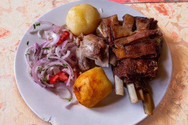 Peru Chicharrn 'ının çıtır çıtır mükemmelliğinin tadını çıkarırken keskin bir taze soğan tekmesiyle servis ediliyor. Her ısırıkta geleneğin gerçek tadı.