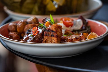 Peru Chicharrn 'ının çıtır çıtır mükemmelliğinin tadını çıkarırken keskin bir taze soğan tekmesiyle servis ediliyor. Her ısırıkta geleneğin gerçek tadı.