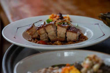 Peru Chicharrn 'ının çıtır çıtır mükemmelliğinin tadını çıkarırken keskin bir taze soğan tekmesiyle servis ediliyor. Her ısırıkta geleneğin gerçek tadı.