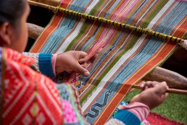 Bir dokumacının elleri, nesiller boyu yetenek, sabır ve yaratıcılık barındırır. Basit iplikleri sanat eserlerine dönüştürür. Her dokuma bir yolculuktur, her düğüm bir anıdır. Chinchero Cusco Peru.