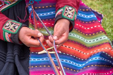 Bir dokumacının elleri, nesiller boyu yetenek, sabır ve yaratıcılık barındırır. Basit iplikleri sanat eserlerine dönüştürür. Her dokuma bir yolculuktur, her düğüm bir anıdır. Chinchero Cusco Peru.