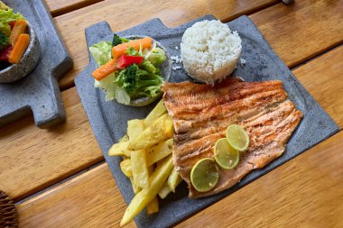 Bu gevrek trucha frita, Cusco usulü, yumuşak pirinç ve taze salatanın yanında altın ve aromalı servis edilir. Gelenek ve lezzetin mükemmel bir karışımı, dağlık sulardan tabağınıza kadar geliyor.