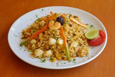 Arroz con Mariscos. Taze deniz ürünleri, taze pirinç ve sizi kıyıların kalbine taşıyan geleneksel Peru baharatlarının mükemmel bir karışımı. Bu yemek okyanusun cömertliğinin gerçek bir kutlaması. Renk ve lezzetle dolup taşıyor.. 
