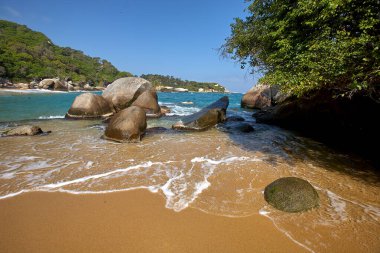 Tayrona Ulusal Parkı 'nın el değmemiş plajları sizi, bereketli tropikal ormanların çerçevelediği turkuaz suların altın kumlarla buluştuğu bir dünyaya davet ediyor. Gerçek bir Kolombiya mücevheri. .