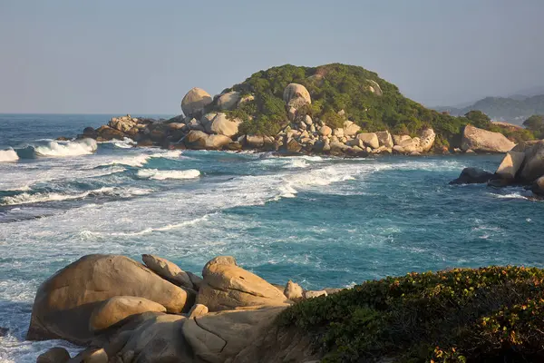 Tayrona Ulusal Parkı 'nın el değmemiş plajları sizi, bereketli tropikal ormanların çerçevelediği turkuaz suların altın kumlarla buluştuğu bir dünyaya davet ediyor. Gerçek bir Kolombiya mücevheri. .