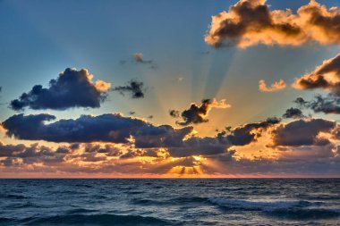 Okyanusun gökyüzüyle buluştuğu kumlu bir sahilde ilk yürüyüşler. Delray Sahili Florida.