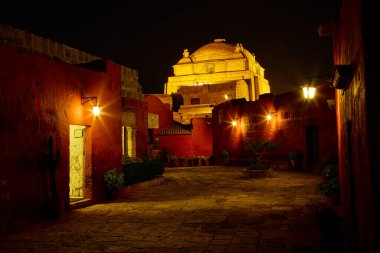 Gecenin sessiz örtüsünün altında, Santa Catalina Manastırı gizemle parıldıyor. Yumuşak fenerlerle aydınlatılan asırlık duvarları, Arequipa 'nın kalbindeki inanç, yalnızlık ve ebedi güzelliğin yankı hikayeleri..