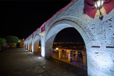 Gece gökyüzünün altında, Yanahuaras kemerleri Arequipa 'nın parlayan kalbini çerçeveler. Şehir ışıkları aşağıda parıldarken, sessiz volkanlar izliyor..