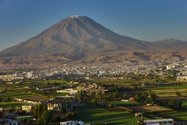 Arka planda yanardağ sisi, Chachani ve Pichu Pichu olan Arequipa yakınlarındaki tarım arazileri.